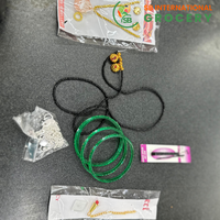 Jewelry items including green bangles, necklaces, and earrings on a dark surface with 'SB International Grocery' branding.